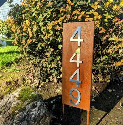 Señal de dirección de metal para la casa